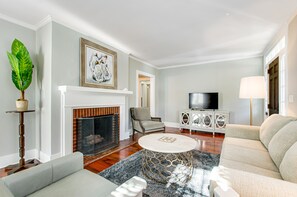 Cozy living room with a fireplace, comfortable seating, and a television.