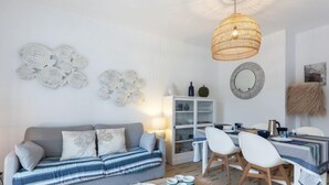Un soggiorno moderno con divano, tavolo da pranzo, sedie e decorazioni a parete.