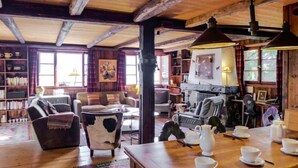Un interior acogedor y rústico con vigas de madera, una chimenea y un comedor listo para el té.