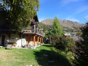 Eine Chalet mit Holzbalkon, Steinwänden und Bergblick.