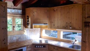 Una cocina de madera con lavavajillas empotrado, una ventana con vistas al exterior y un fregadero.