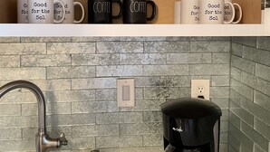 Ett kök med en diskho, kran och kaffebryggare.