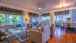 A spacious living area with a wooden ceiling, a dining table, and a sofa. - Molokai Oceanfront large beautiful home - Gorgeous secluded beaches out front! (Maunaloa)