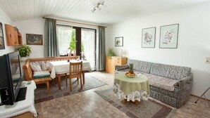 Een gezellige woonkamer met een bank, een eettafel en een televisie.
