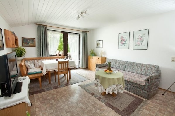 Un salon confortable avec un canapé, une table à manger et un téléviseur.