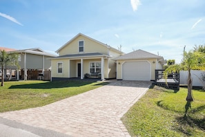 A two-story house with a covered patio, a garage, and a paved driveway. - Sailing Mood by Distinctive Beach Rentals (Palm Coast)