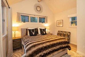 A bedroom with a bed, two bedside tables, a window, and a wall-mounted decor piece. - Alpine Retreat - Donner Lake - Walk to West End Beach (Truckee)