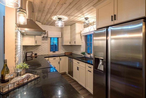 Enjoy cooking in this well-equipped kitchen with a large refrigerator, oven, and wine cooler.