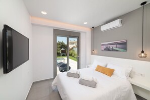 Une chambre moderne équipée d’un lit, d’un téléviseur à écran plat, d’un système de climatisation et offrant une vue sur l’extérieur.