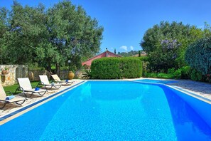 A clear blue swimming pool with lounge chairs and a stone wall. - Votana House - Vacation villa with private pool on Corfu, Greece (Kassiopi)
