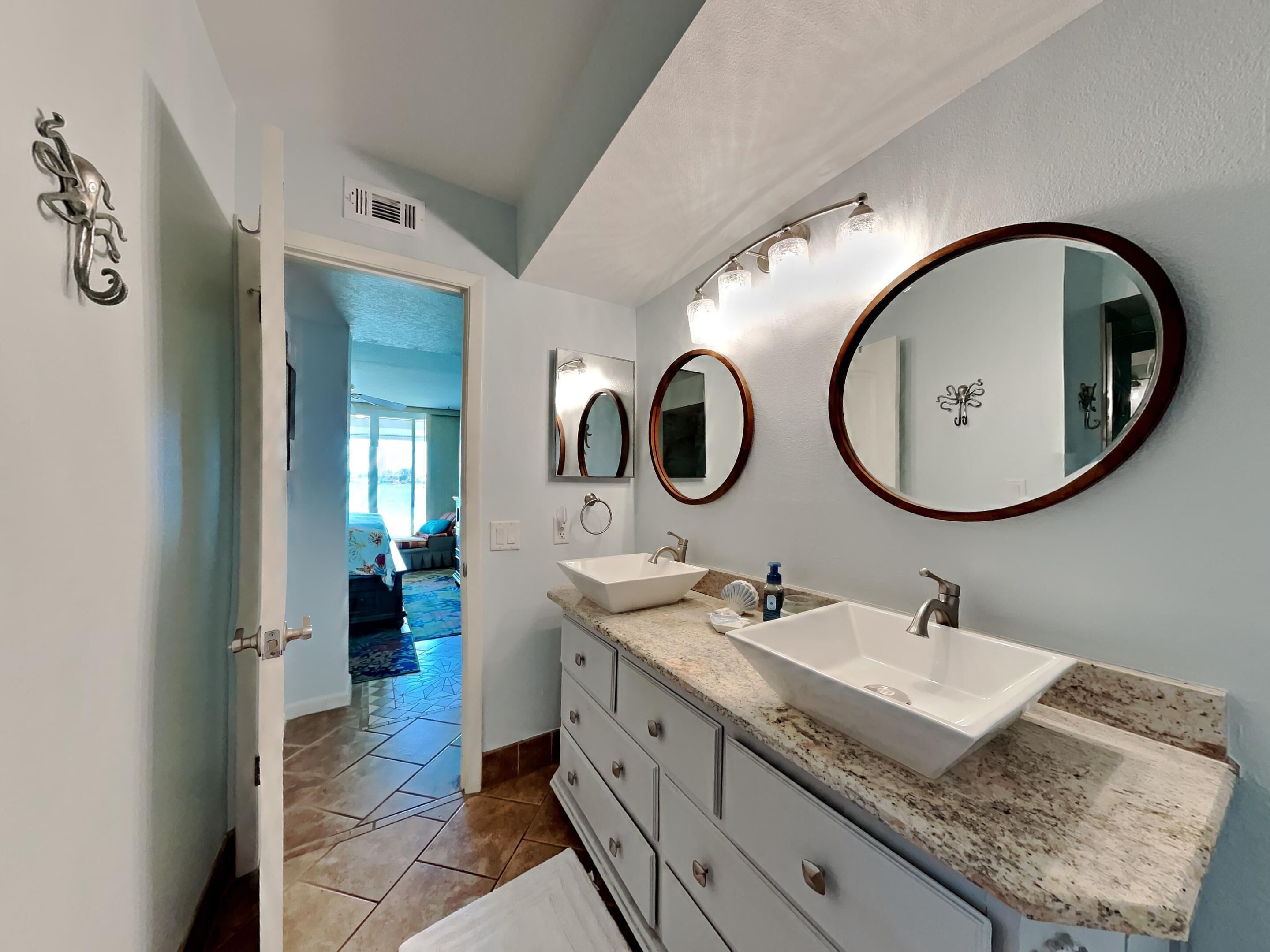 A bathroom with two sinks, a vanity, and a large mirror.