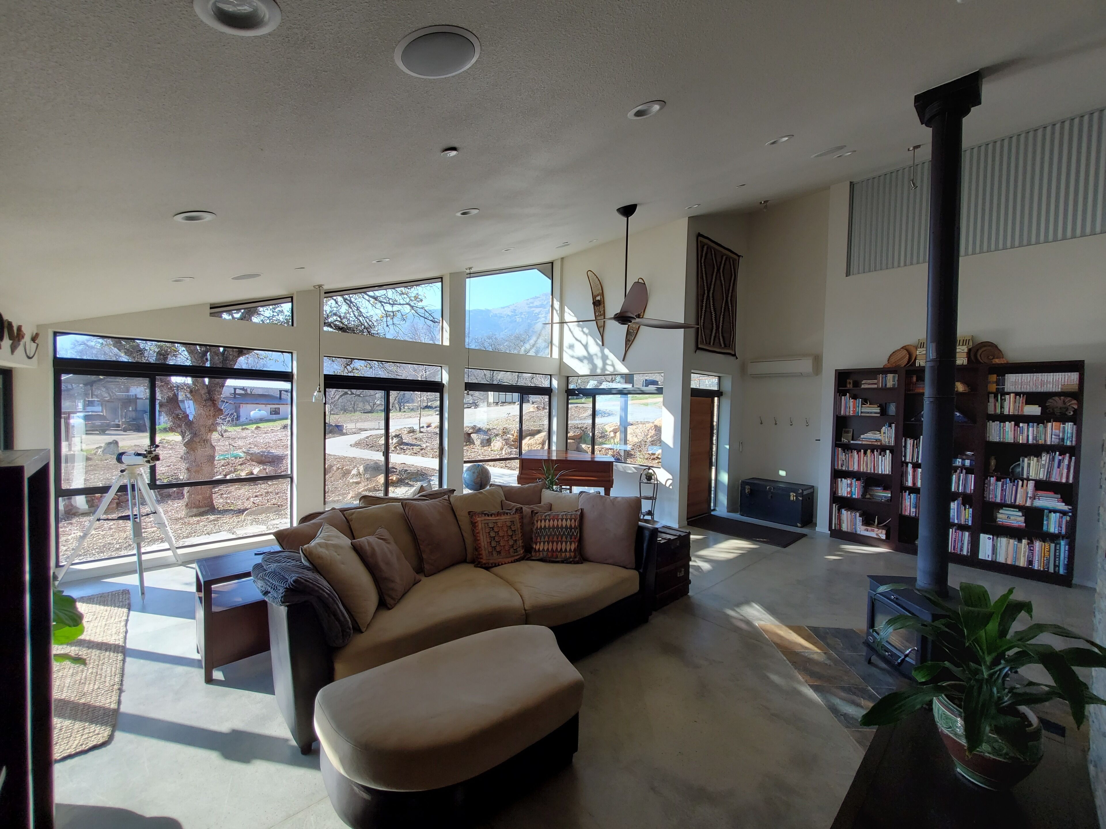 A spacious living room with a large sectional sofa, a coffee table, and a bookshelf.