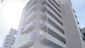 A multi-story building with a modern architectural design, featuring balconies on each floor. - OUCHI HOTEL Hijiyama (Hiroshima)