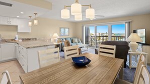 Amplia sala de estar con una isla grande, muebles de madera y vistas al exterior.