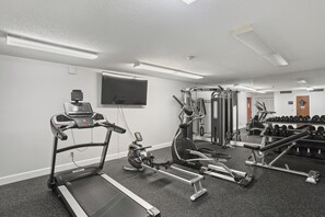 A gym with treadmills, elliptical machines, and free weights.