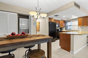 A modern kitchen with a central island, wooden cabinets, and a built-in oven. - 🌴 Gulf Gate Resort Unit 201 – Updated 1BR Condo with Gulf Views & Premium Comfort (St Pete Beach)