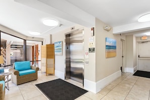 Welcome to our lobby, featuring a reception area with a comfortable chair and elevator access.