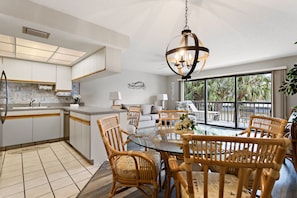 Enjoy meals at the central island and dining table, surrounded by comfortable seating and a chandelier.