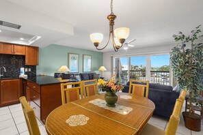 Enjoy a warm and inviting space with a dining table, kitchen, and natural light.