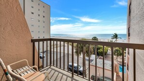 Ein Balkon mit Blick auf Strand und Meer.