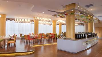 A modern dining area with a central bar, multiple seating options, and a decorative ceiling.