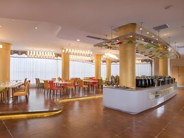 Un comedor moderno con una barra central, diversas opciones de asientos y un techo decorativo.