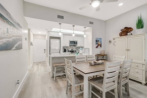 A modern kitchen with white cabinets, a microwave, and a sink.