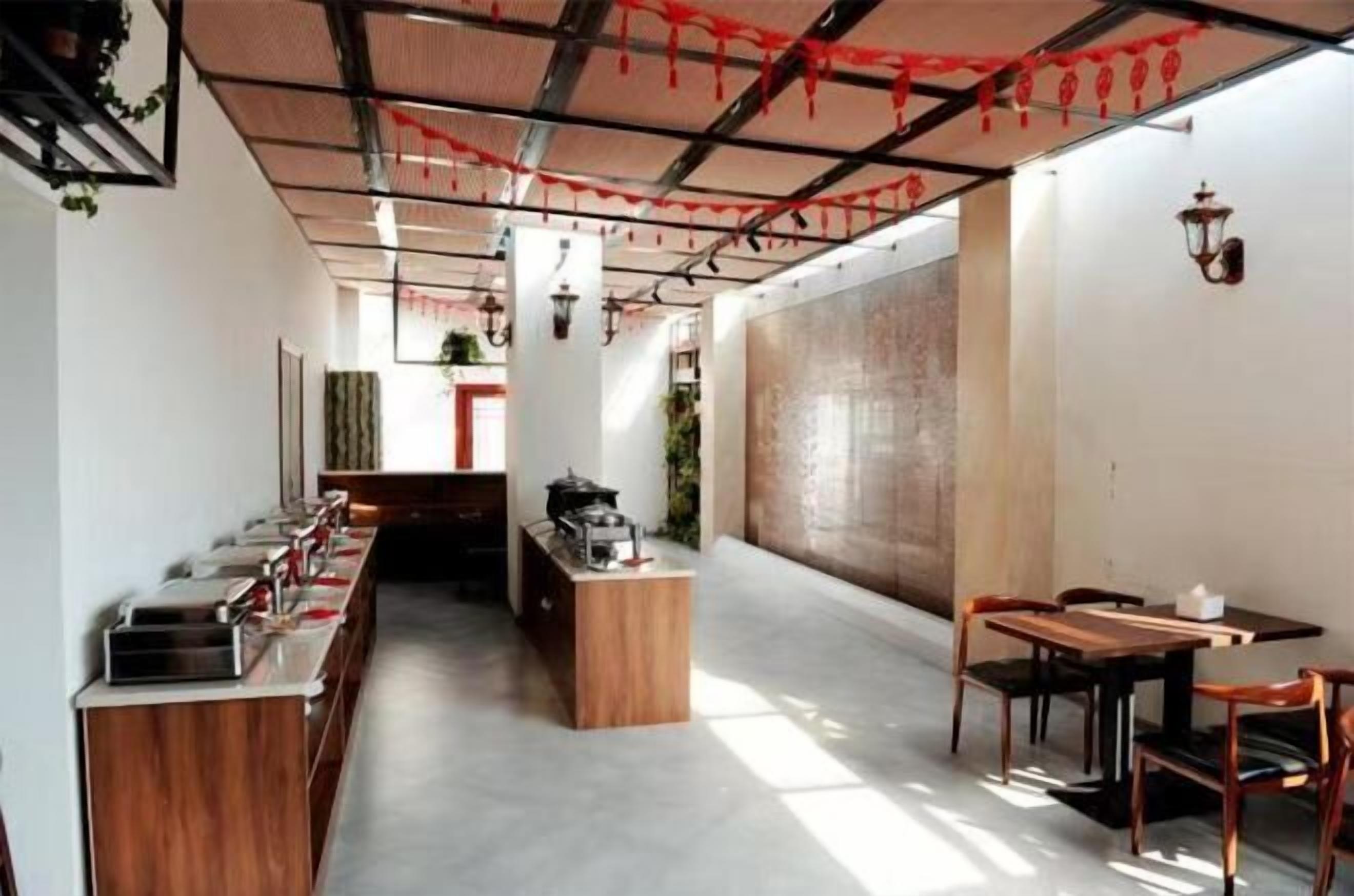 A modern restaurant with a long counter, wooden stools, and a central island.