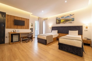 Habitación de hotel con dos camas, un escritorio, un televisor y un cuadro en la pared.