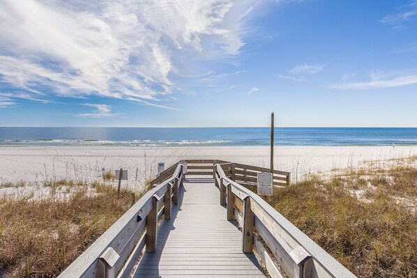 A wooden boardwalk leading to a beach with a clear sky. - Tidewater 208 | Pools, Gym, Hot Tub, Wifi | Private Balcony | Ocean Front Views (Orange Beach)