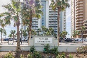A sign for the Tidewater Condominium with a view of tall buildings and palm trees in the background. - Tidewater 208 | Pools, Gym, Hot Tub, Wifi | Private Balcony | Ocean Front Views (Orange Beach)