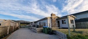 A residential property with a covered patio, a fenced yard, and a stone chimney. - Coastal Retreat - 400m walk to Rosebud Beach (Rosebud)