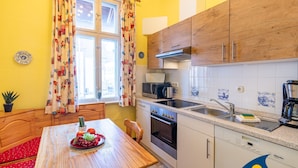 A kitchen with wooden cabinets, a microwave, an oven, and a sink. - Beach villa Whg 01 - SVB 01 (Heringsdorf)