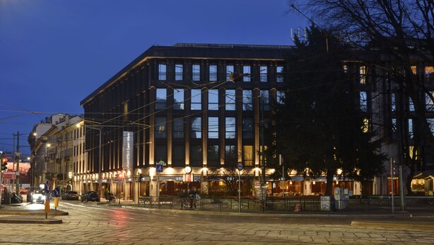 A modern building with multiple floors, large windows, and a well-lit facade. - Milano Castello Luxury Apartment (Milan)