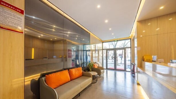 A modern lobby with a sofa, a reception desk, and a glass partition. - Rest Hotel (Lanzhou West Railway Station Lanzhou Old Street) (Lanzhou)