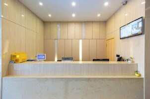 Un área de recepción con mostrador, computadora y un mapa enmarcado en la pared.