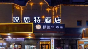 A hotel with a prominent sign featuring Chinese characters and a logo. - Rest Hotel (Lanzhou West Railway Station Lanzhou Old Street) (Lanzhou)