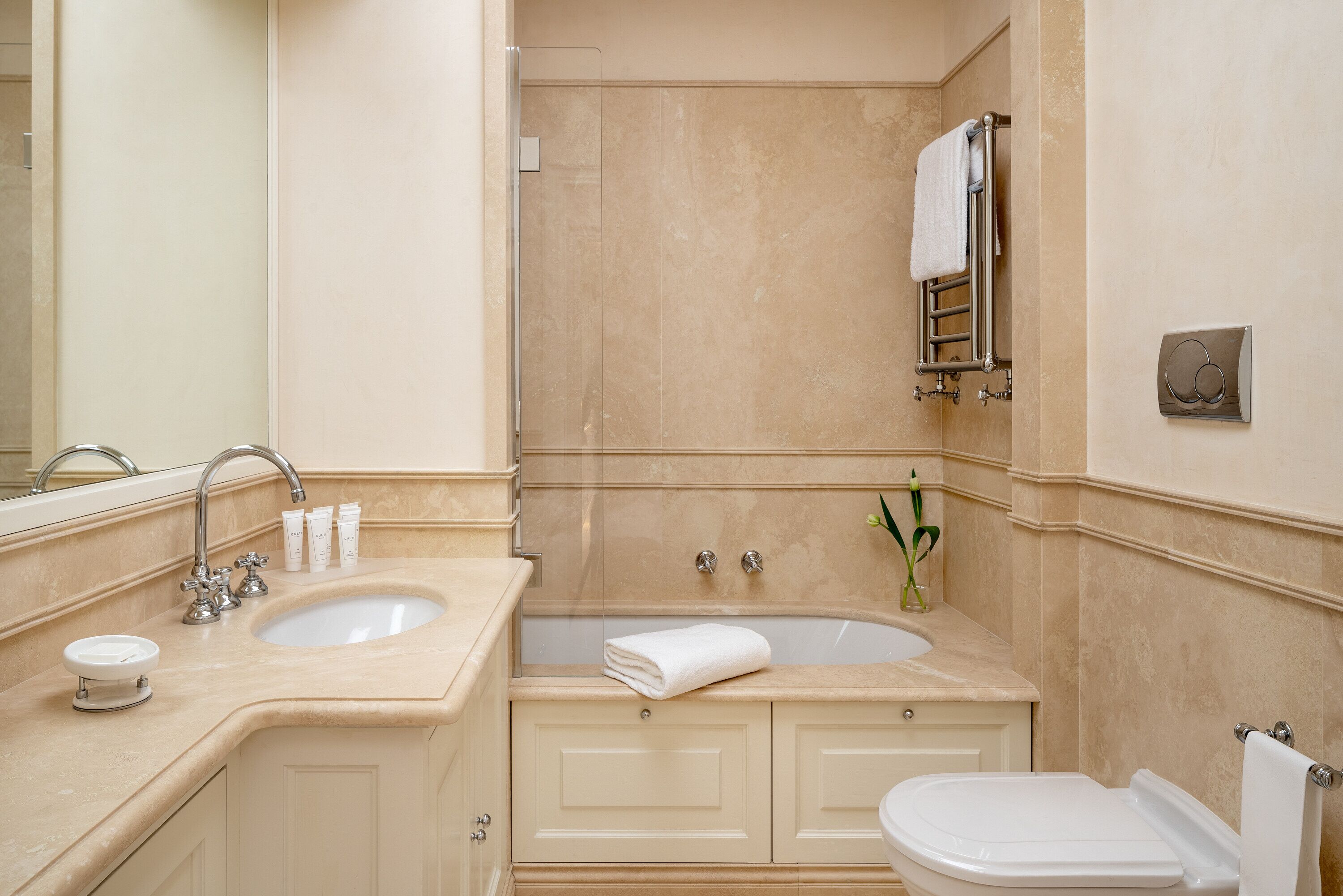 Un baño con lavamanos doble, bañera, inodoro y espejo.