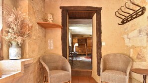 A rustic room with two wicker chairs, a vase with dried plants, and a wooden table. - Superb Holiday Home in Busse with Swimming Pool (Besse)