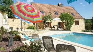 A swimming pool with lounge chairs and a colorful umbrella. - Superb Holiday Home in Busse with Swimming Pool (Besse)
