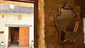 A rustic stone building with a wooden door and a large ornate mirror on the wall. - Superb Holiday Home in Busse with Swimming Pool (Besse)