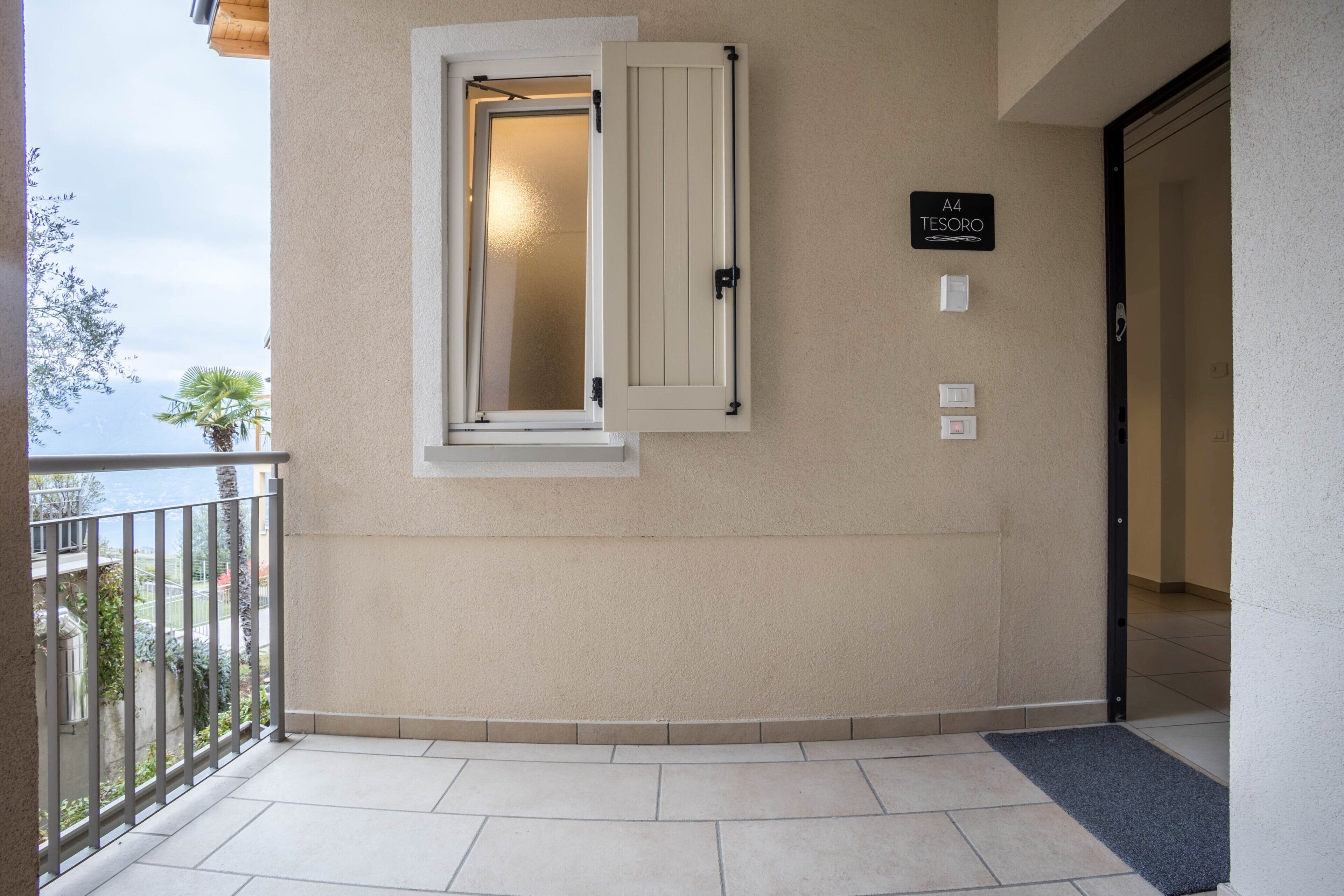 L’entrée d’un hôtel avec une porte fermée, un balcon doté d’une balustrade et une enseigne indiquant la chambre A4.