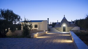 A modern building with a stone facade and a conical roof structure. - ROMANTIC OR FAMILY RENTAL (Ceglie Messapica)