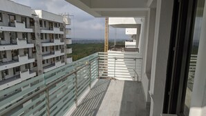 A balcony with a glass railing overlooking a residential area and a distant view of a construction crane. - Premium Apartment in Copou (Iași)