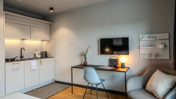 Une cuisine moderne avec un coin repas, un téléviseur à écran plat et un espace salon confortable.