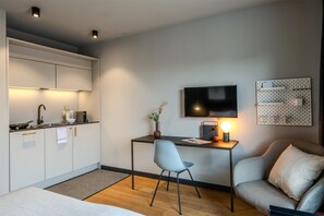 Une cuisine moderne avec un coin repas, un téléviseur à écran plat et un espace salon confortable.