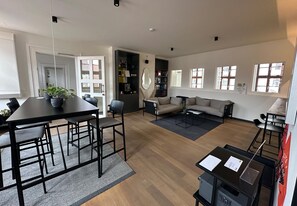 A spacious living area with a dining table, sofa, and a bookshelf. - ipartment Wolfsburg @HOME by Best Western (Wolfsburg)