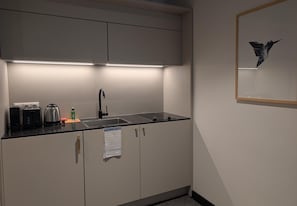 A modern kitchen with a built-in oven, a coffee maker, and a kettle on the countertop. - ipartment Wolfsburg @HOME by Best Western (Wolfsburg)