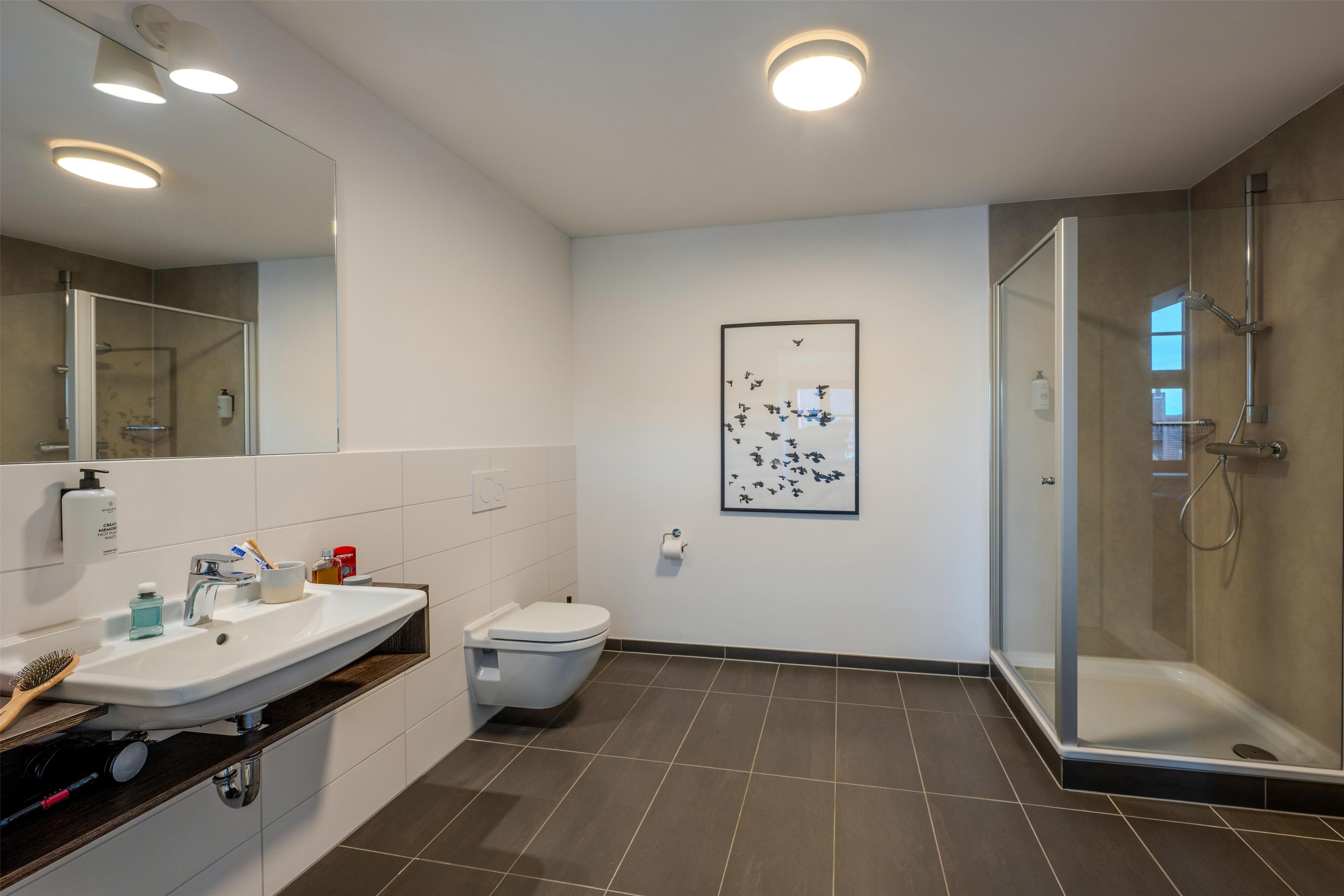 Un baño moderno con ducha, inodoro y lavabo.