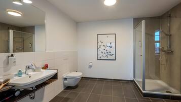 Un baño moderno con ducha, inodoro y lavabo.